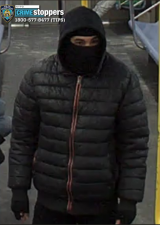 Surveillance photo of suspect on J train. Note “shiesty mask” and fingerless gloves.