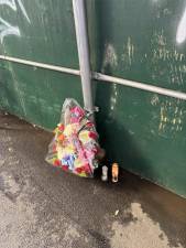 A memorial wreath and votive candles lay against a fence surrounding the job site where construction worker Jose Ramirez Munoz was killed when the cherry picker he was in hoisted him into a steel beam 32 ft above the ground.