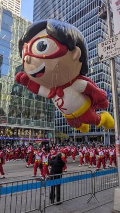 <b>Macy’s volunteers hold the guide ropes for Red Titan, a superhero character from the cartoon show “Ryan’s World.”</b> Photo: Brian Berger