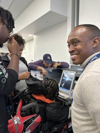 Disabled individual trying out the Ballot Marking Device for the first time while trained ADA workers supervise. Photo: Vanessa Torres