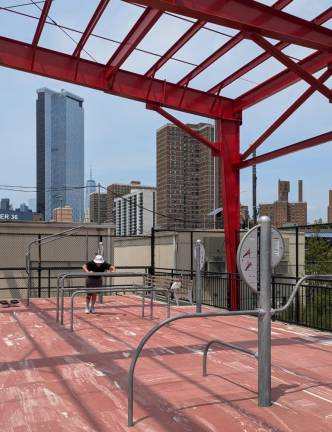 Man doing incline push-ups on the parallel dip bars at Pier 42. The tall building at left is One Manhattan Square in the erstwhile “Two Bridges” section of Chinatown.