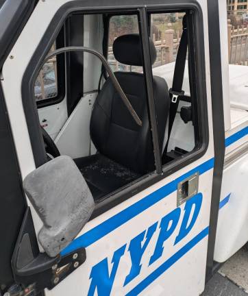 The window of the NYPD golf cart is smashed. No police in sight.