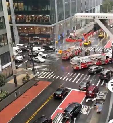 <b>Firefighters block off an intersection in Chelsea after steel construction plates in the roadway were moved by floodwaters</b>. Photo: Citizens app