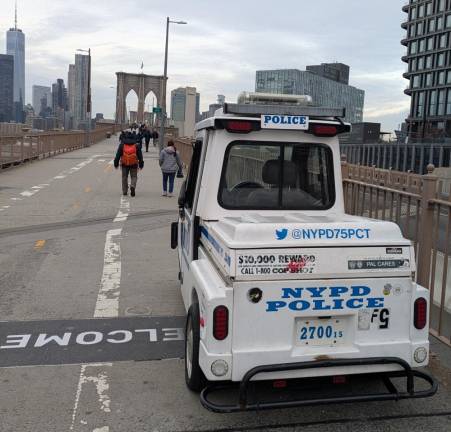 An empty NYPD three-wheel golf cart with a smasked window is the bridge’s only security.