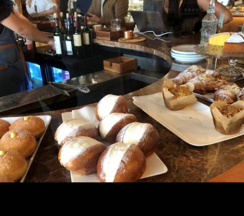 <i><b>At Travelers Poets &amp; Friends café and bakery you can start the day with espresso and pastry, Italian style, like these cream-filled maritozzi. At night, this becomes a candle-lit wine bar.</b></i><b> </b>