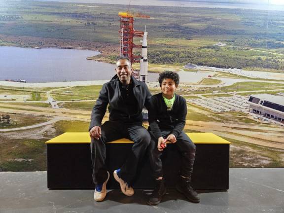 A father/son duo pose for a picture in the room housing the Enterprise space shuttle.