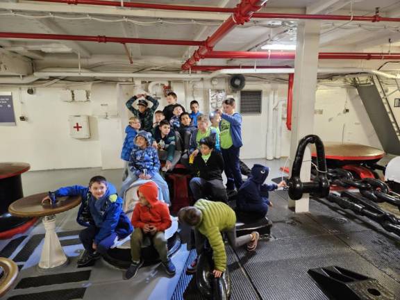 One group of kids pose in the anchor room, in the nose of the Intrepid aircraft carrier.