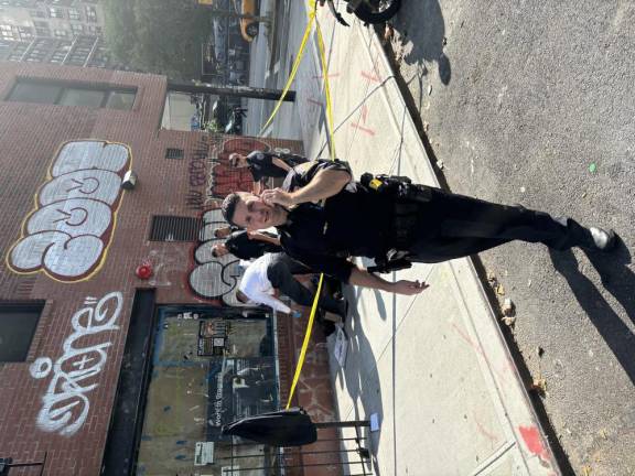 Police phone in a DOA for a yet-to-be-identified 59-year-old male found on W. 29th just off of Eighth Ave. shortly after 8:30 a.m. on Sept. 16. An officer in a white shirt works to throw a cover over the deceased. A pizza box and a container of takeaway can be seen on the sidewalk.