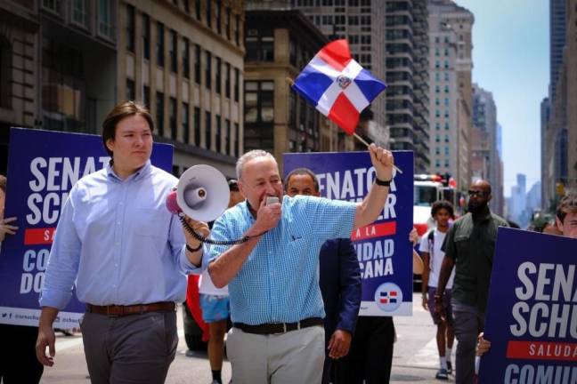 A man and his bullhorn: Dominican flag waving Sen. Charles Schumer rocks the microphone while an aide holds the bullhorn proper.