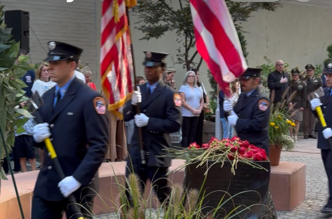 An FDNY color guard streams pass the fountain in the vest pocket memorial park on W. 48th St. where friends and family members left red roses in memory of the 15 firefighters who died on 9-11 at Battalion 9, Engine 54, Truck 4 firehouse. It was the house that suffered the most casualties on 9-11.