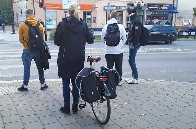 Europeans seem much more likely to obey the rules of the road such as this woman who uses her bicycle every day to commute to work in Tomaszów Mazowiecki, Poland–stops and dismounts at an intersection, obeying local traffic rules of the road. Photo: Wikimedia Commons