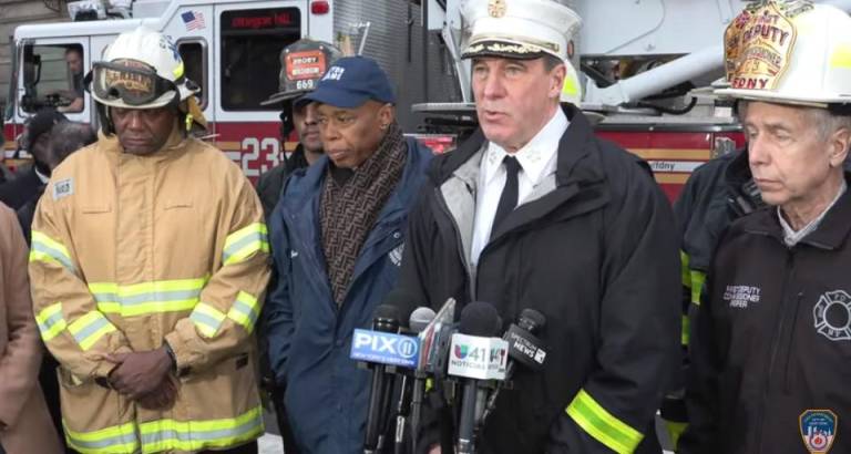 FDNY Chief of Dept John Hodgens (at mic) with Mayor Eric Adams at a fatal fire in Harlem in Feb. that was started by exploding lithium ion batteries. The fire caused the first death related to faulty lithium ion batteries in 2024. Last year, 18 were killed in the city from the faulty devices. Photo: FDNY/You Tube.