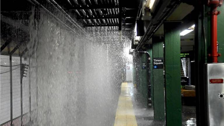 Gallons of water pour onto the subway tracks at the Times Square station, after a water main burst in the area in the wee hours of Tuesday, August 29. Subway service had partially resumed by 11 a.m.